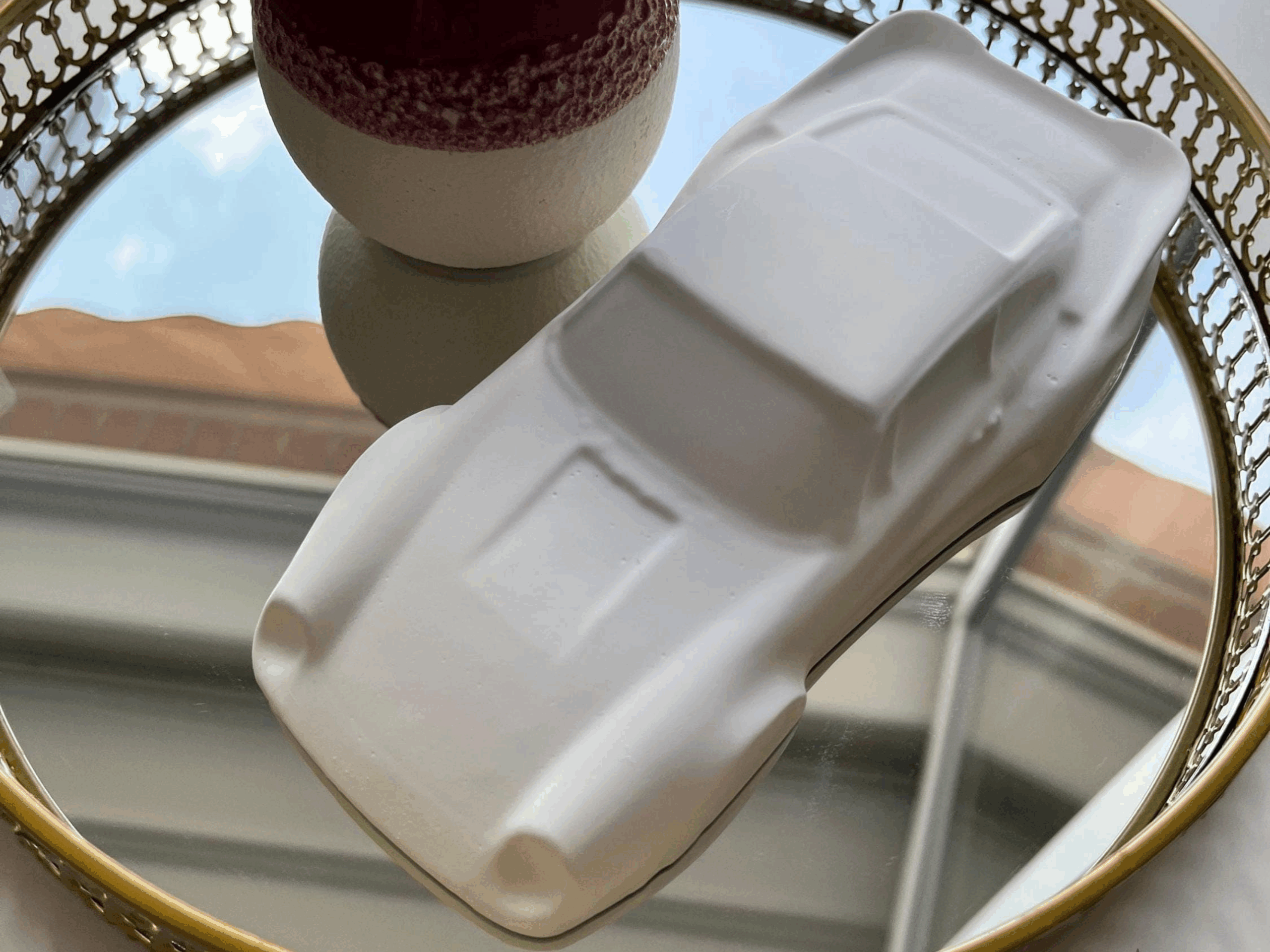 Keramikmodell von Porsche inspiriert auf einem spiegelnden Untergrund